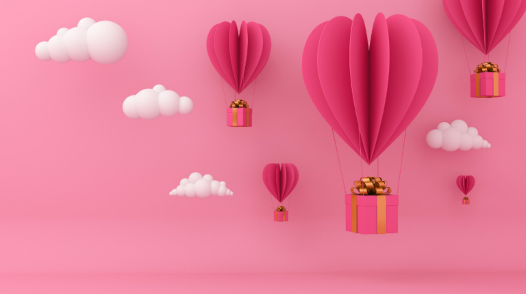 Pink background with darker pink heart shaped paper decorations that are mimicking hot air balloons. White clouds are surrounding them.